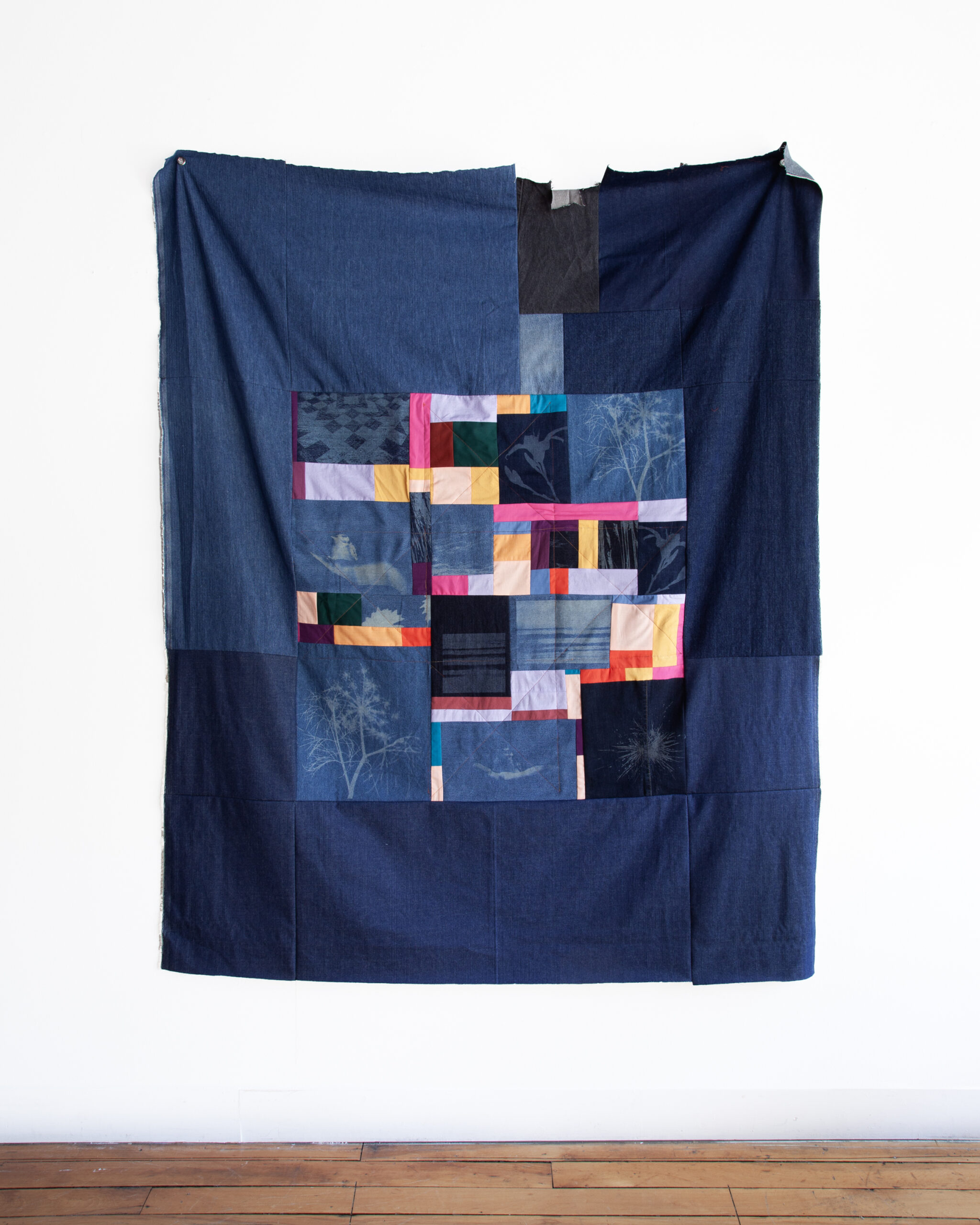 Leaves No Remnant, 2024, laser-etched denim, cotton fabric, worn jeans, thread, 50” x 60”